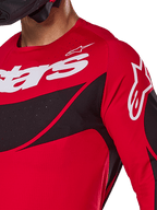 Alpinestars 2025 Techstar Dreem Jersey, camisola de motocross, vermelha e preta, vista de pormenor do peito e ombro com logótipos brancos, painéis diagonais pretos com perfurações a laser para ventilação, corte atlético de corrida para performance em todo-o-terreno
