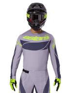 Conjunto de Jersey e Equipamento Techstar Dreem 2025, fato de corrida de motocross, cinzento claro e cinzento escuro com pormenores em amarelo néon, inclui a marca 'astars', usado com capacete preto, óculos e luvas a condizer, material técnico perfurado para performance todo-o-terreno