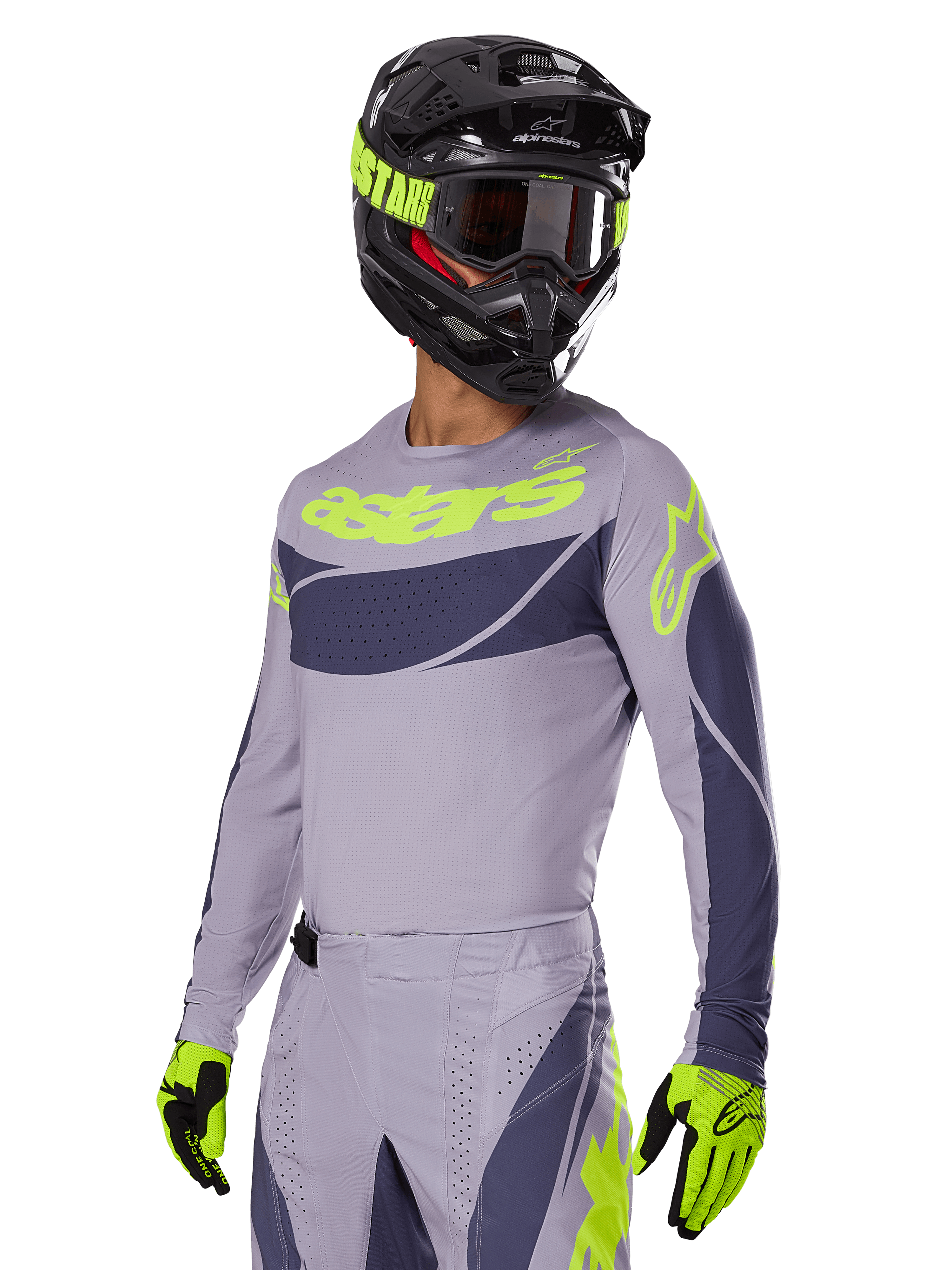 Motocross rider wearing the Alpinestars 2025 Techstar Dreem Jersey in Gray and Dark Gray, featuring a neon yellow 'astars' logo on the chest, paired with a matching helmet, goggles, and gloves for a coordinated off-road racing look