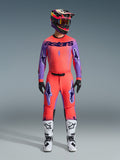 2026 Supertech Scenz Gear Set, Alpinestars Motocross Racing Outfit, vibrant red-orange and purple, jersey with black 'astars' branding, matching pants with purple star logos, colorful racing helmet, and white boots, professional off-road performance kit