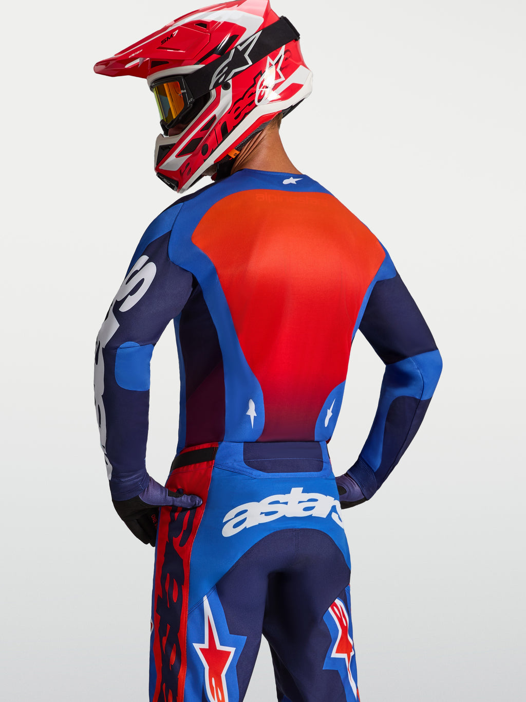 Alpinestars Camisola Racer Hunt, camisola de motocross para homem, azul e vermelha, vista traseira, ajuste de corrida ergonómico e tecido que afasta a humidade.