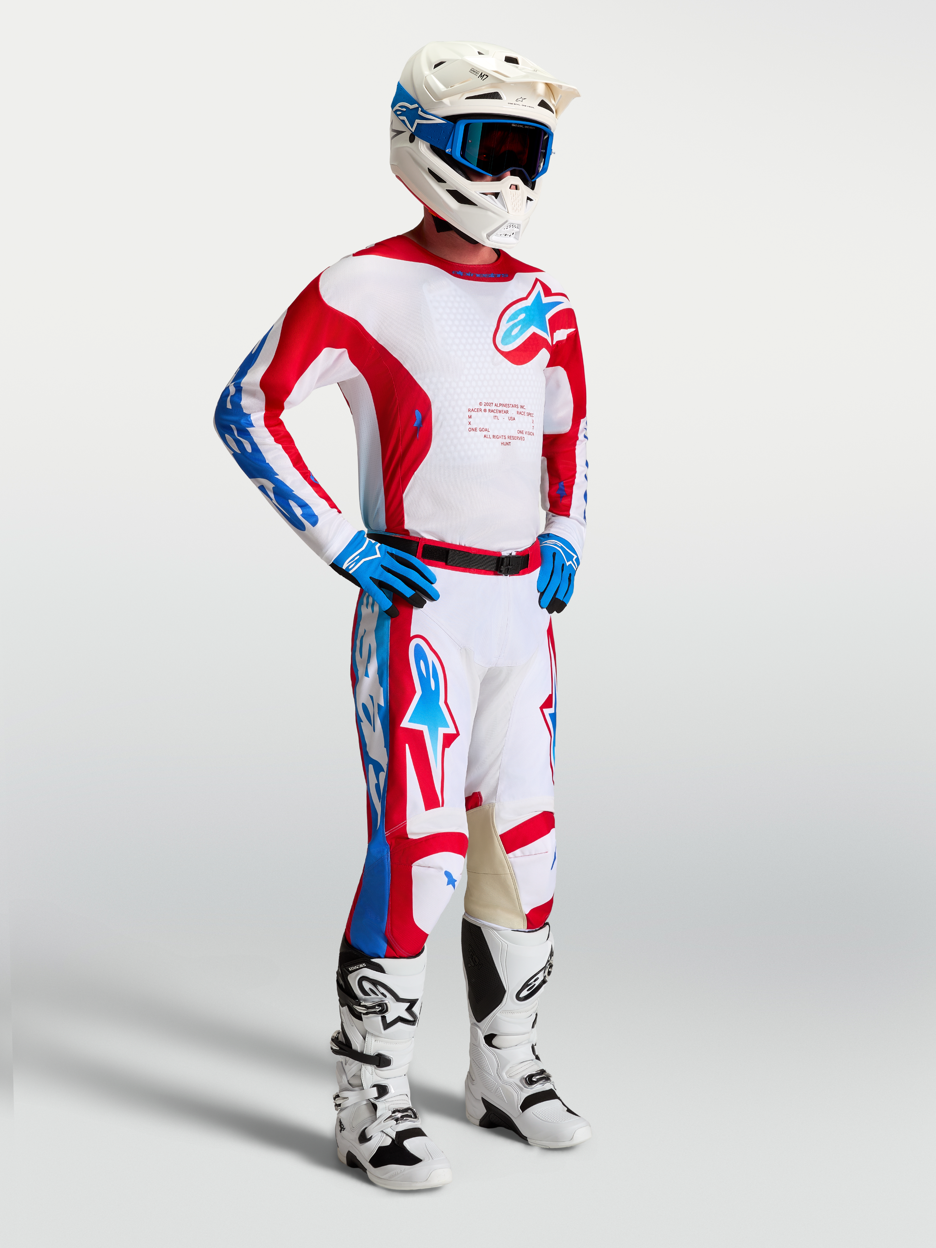Alpinestars Racer Hunt, camisola de motocross para homem, branca, vermelha e azul, tecido leve com absorção de humidade, modelo a usar o equipamento completo de corrida off-road