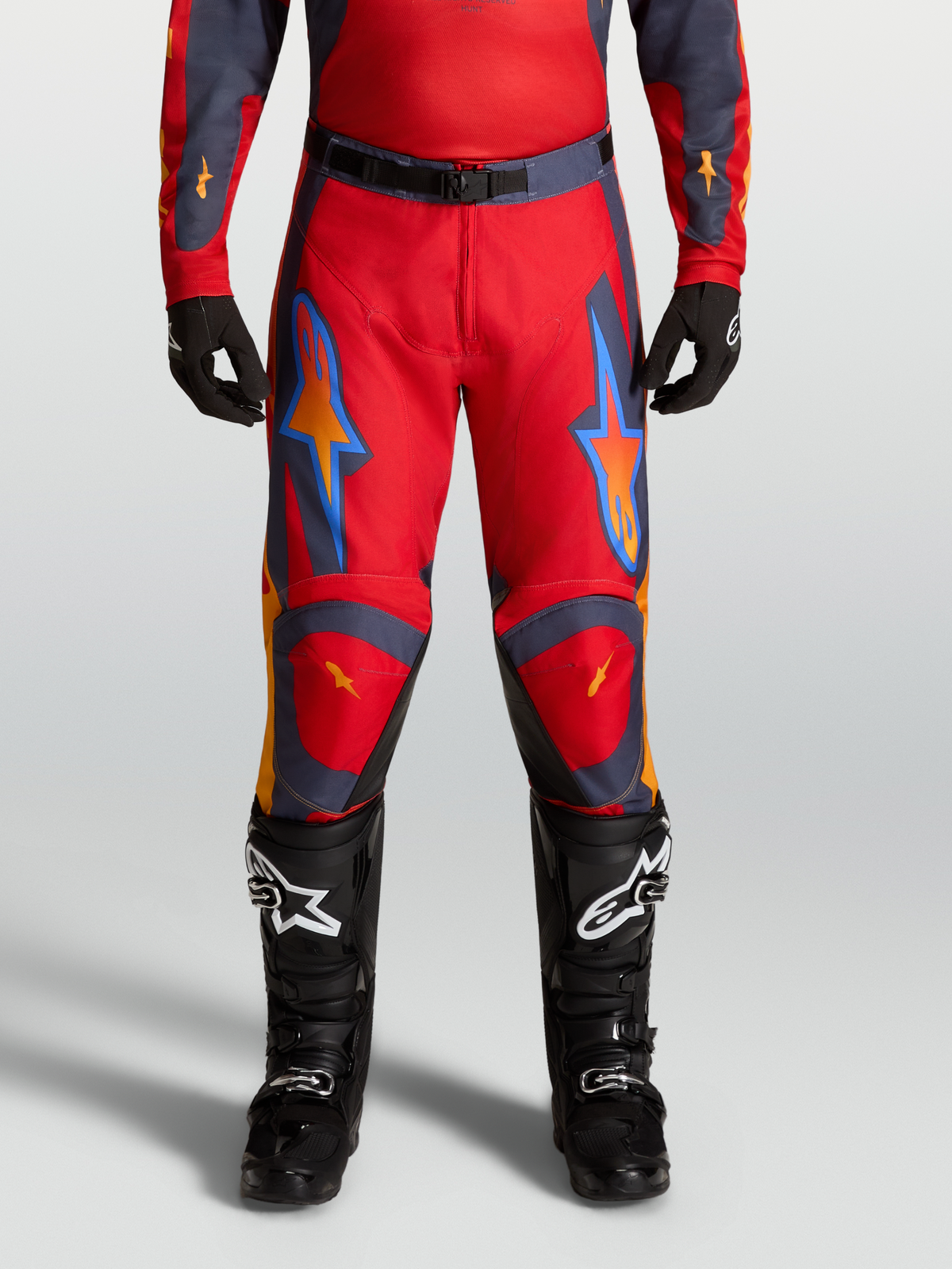 Alpinestars Calças Racer Hunt 2027 no modelo, calças de motocross para homem, vermelhas e cinzentas, ajuste pré-curvado.