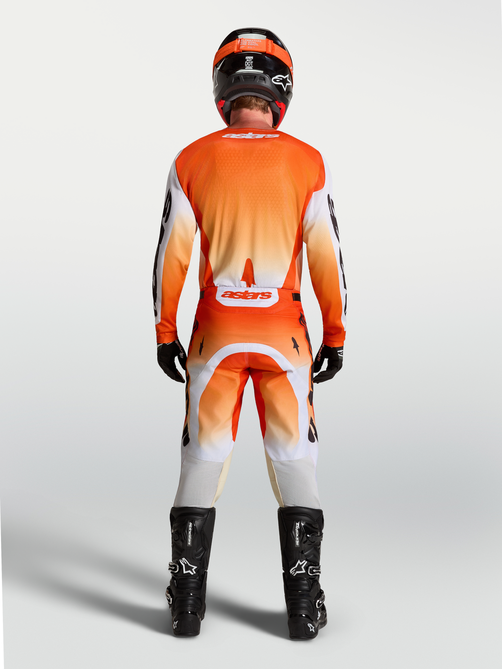 Alpinestars Camisola Racer Amber, vista traseira no modelo, camisola de motocross laranja e branca, respirável.