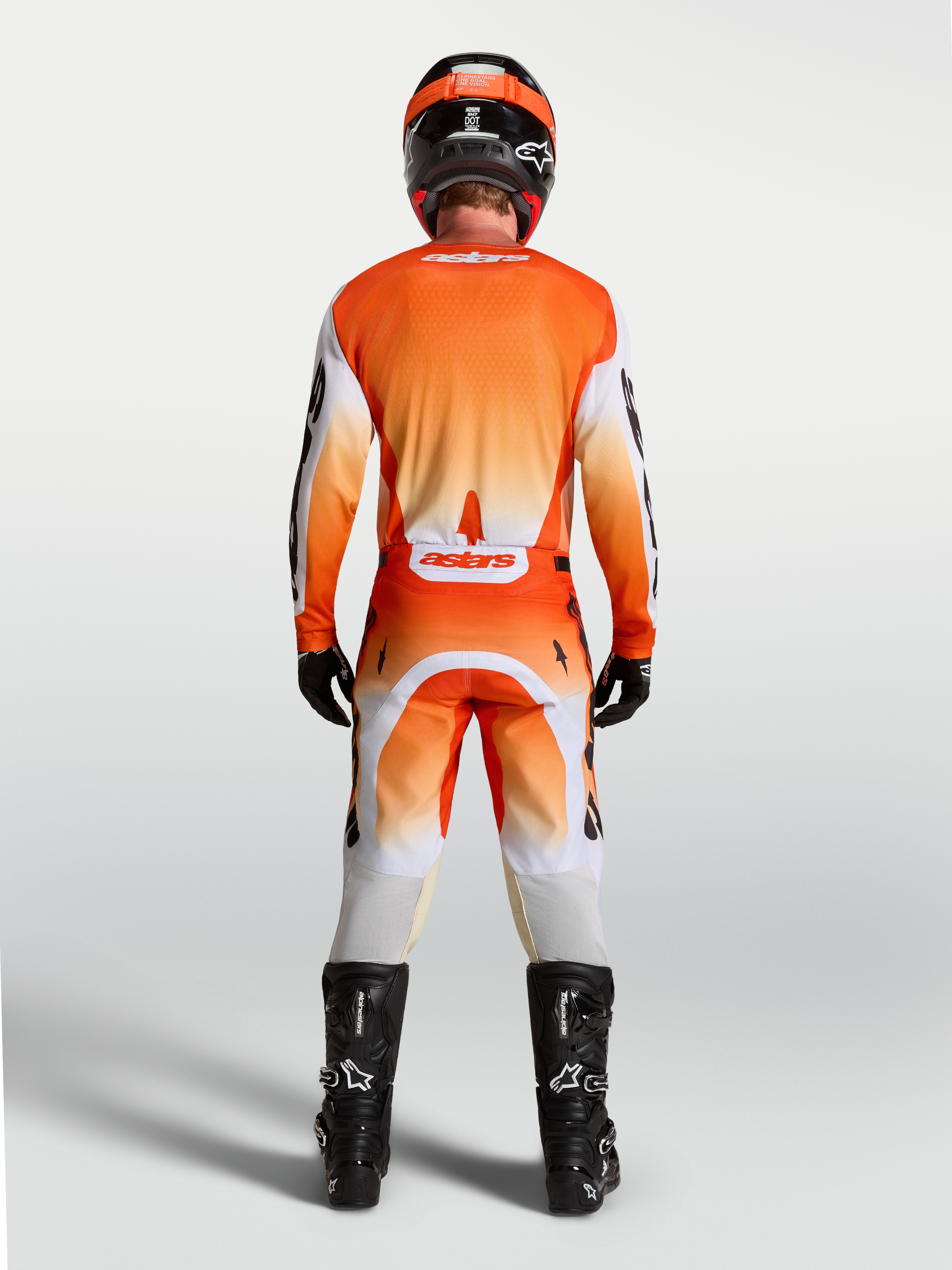 Alpinestars Camisola Racer Amber, vista traseira no modelo, camisola de motocross laranja e branca, respirável.