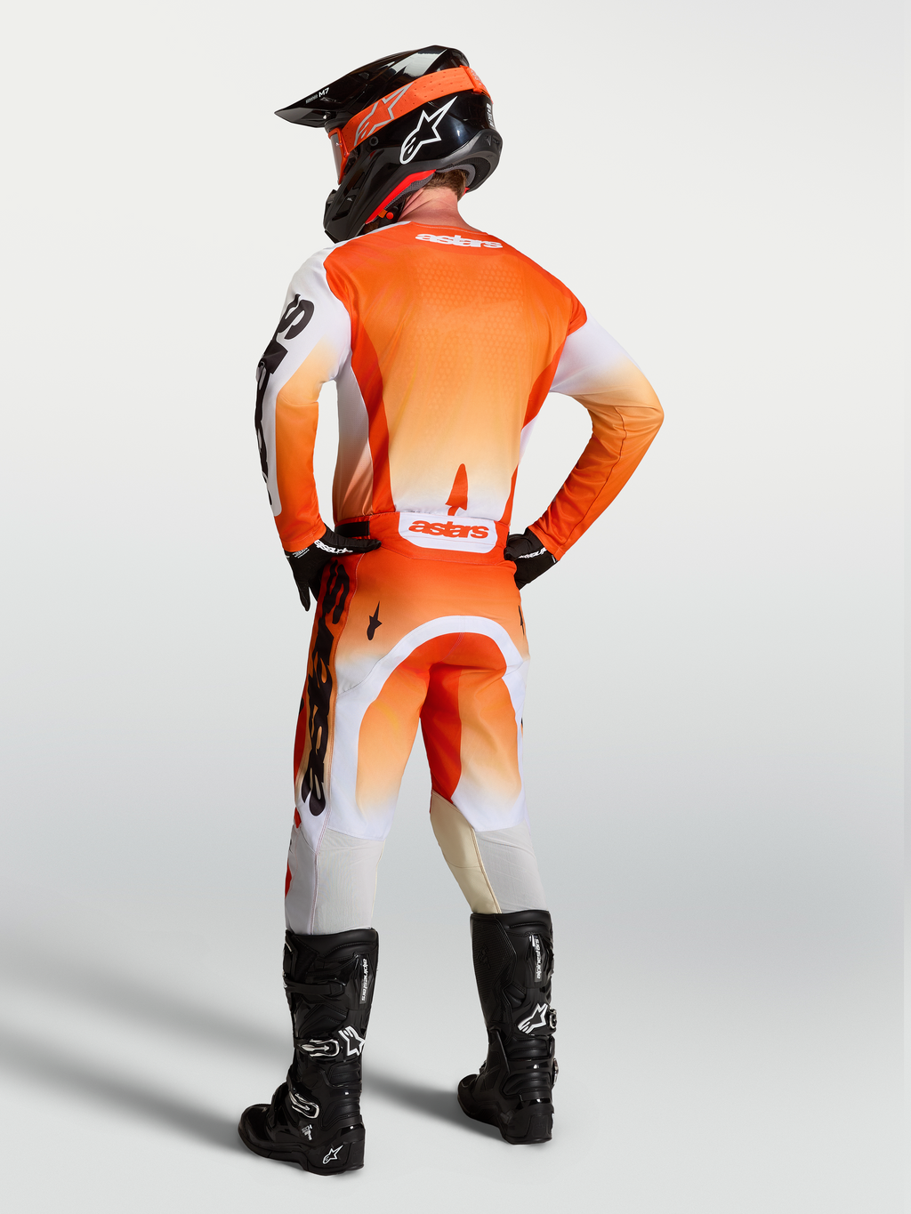 Alpinestars Calças Racer Amber e Racer Amber Gear Set, conjunto de motocross para homem, laranja e branco, vista traseira no modelo com ajuste de corrida.