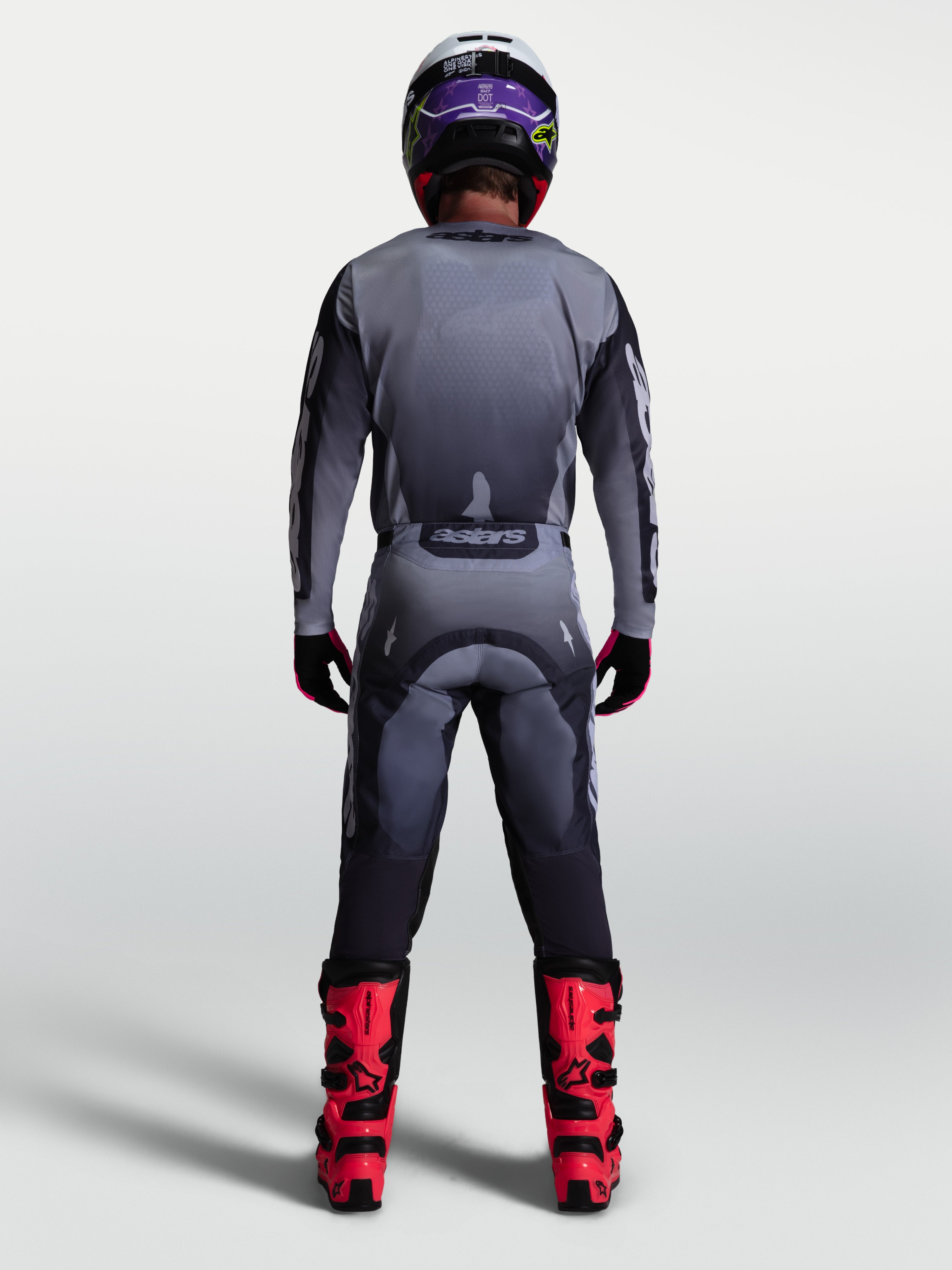 Conjunto Alpinestars Racer Amber 2027, camisola e calças de motocross cinzentas e lilás, vista traseira no modelo.