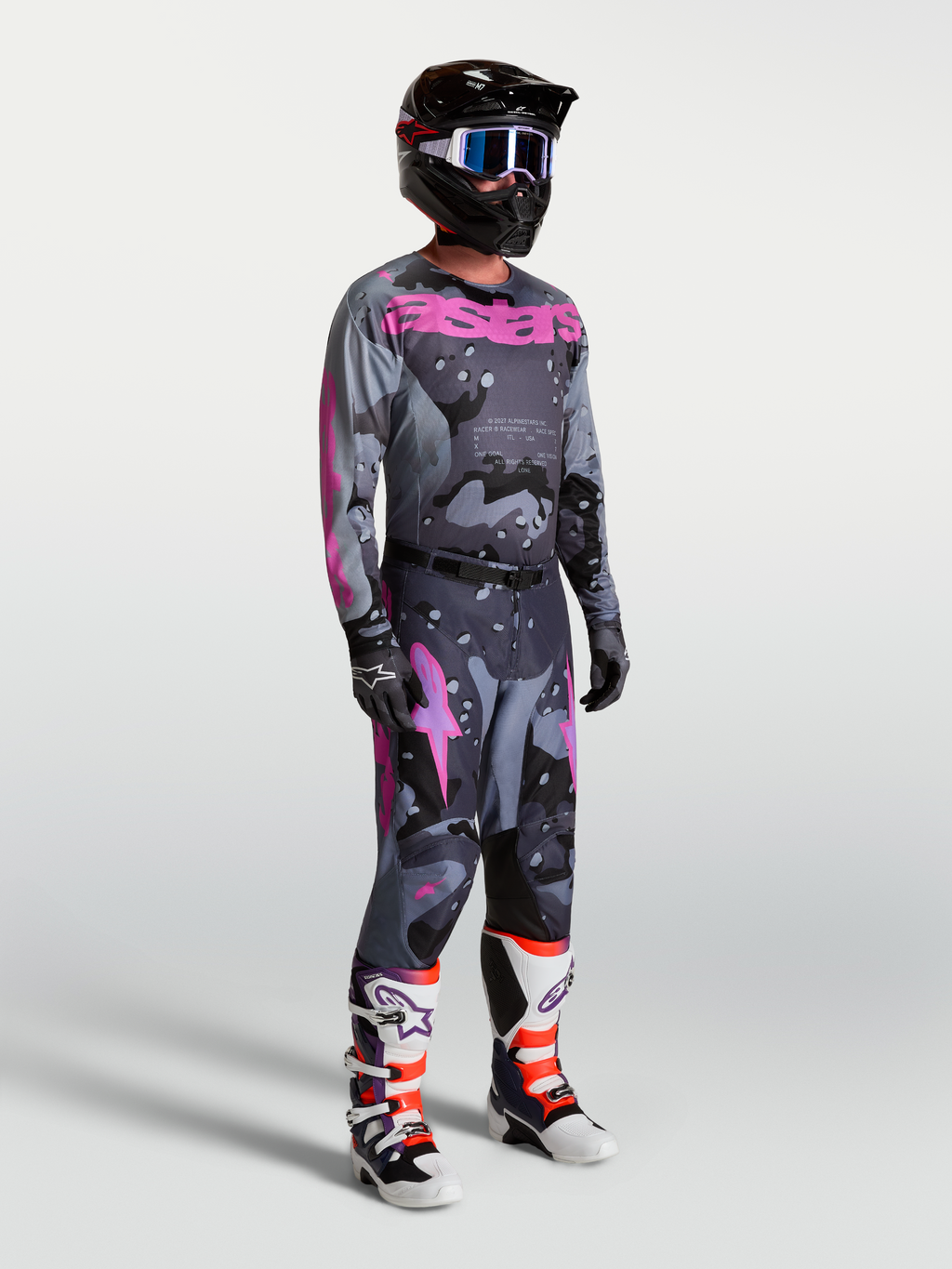 Alpinestars Racer Lone, conjunto de camisola e calças de motocross para homem, cinzento e roxo camuflado com botas e capacete.