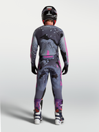Alpinestars Racer Lone, conjunto de motocross em cinzento camuflado e roxo, vista traseira do piloto com equipamento completo.
