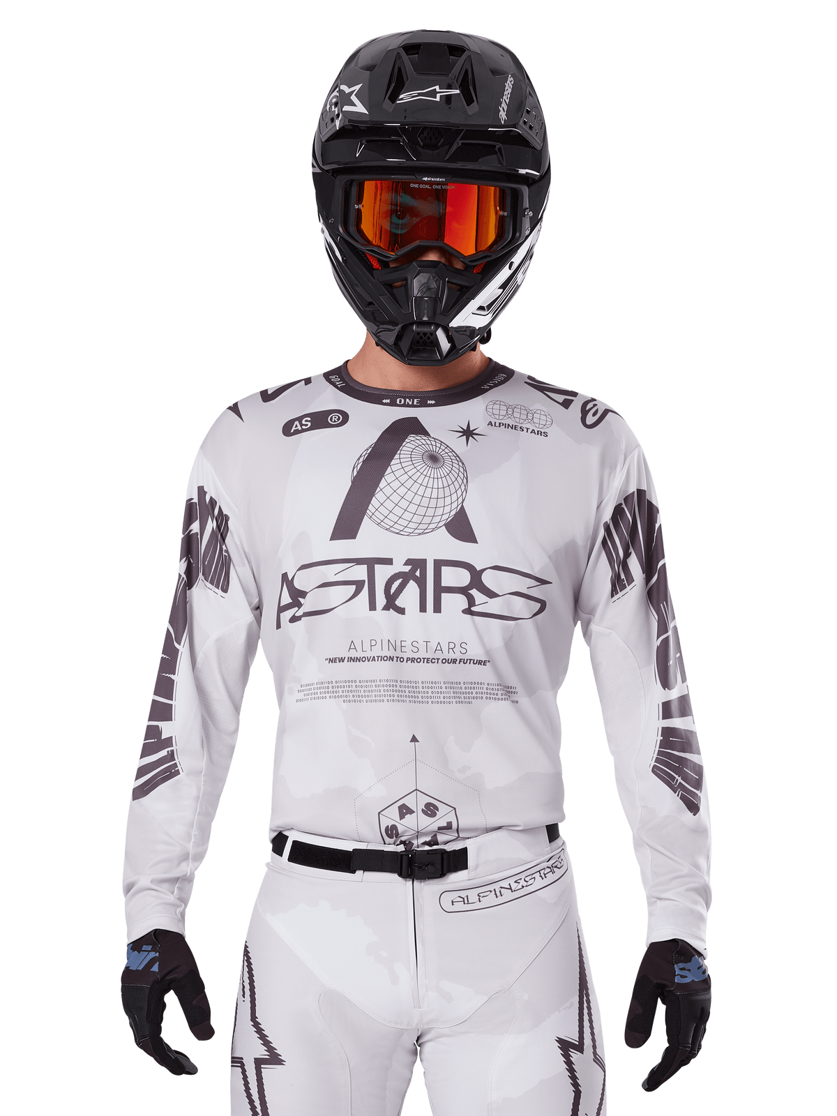 Camisola Alpinestars Racer Hollow 2025, camisola de motocross, branca e preta, usada com calças de MX brancas a condizer e capacete preto com óculos laranja, com logótipos Alpinestars e gráficos de globo, equipamento profissional de corrida todo-o-terreno