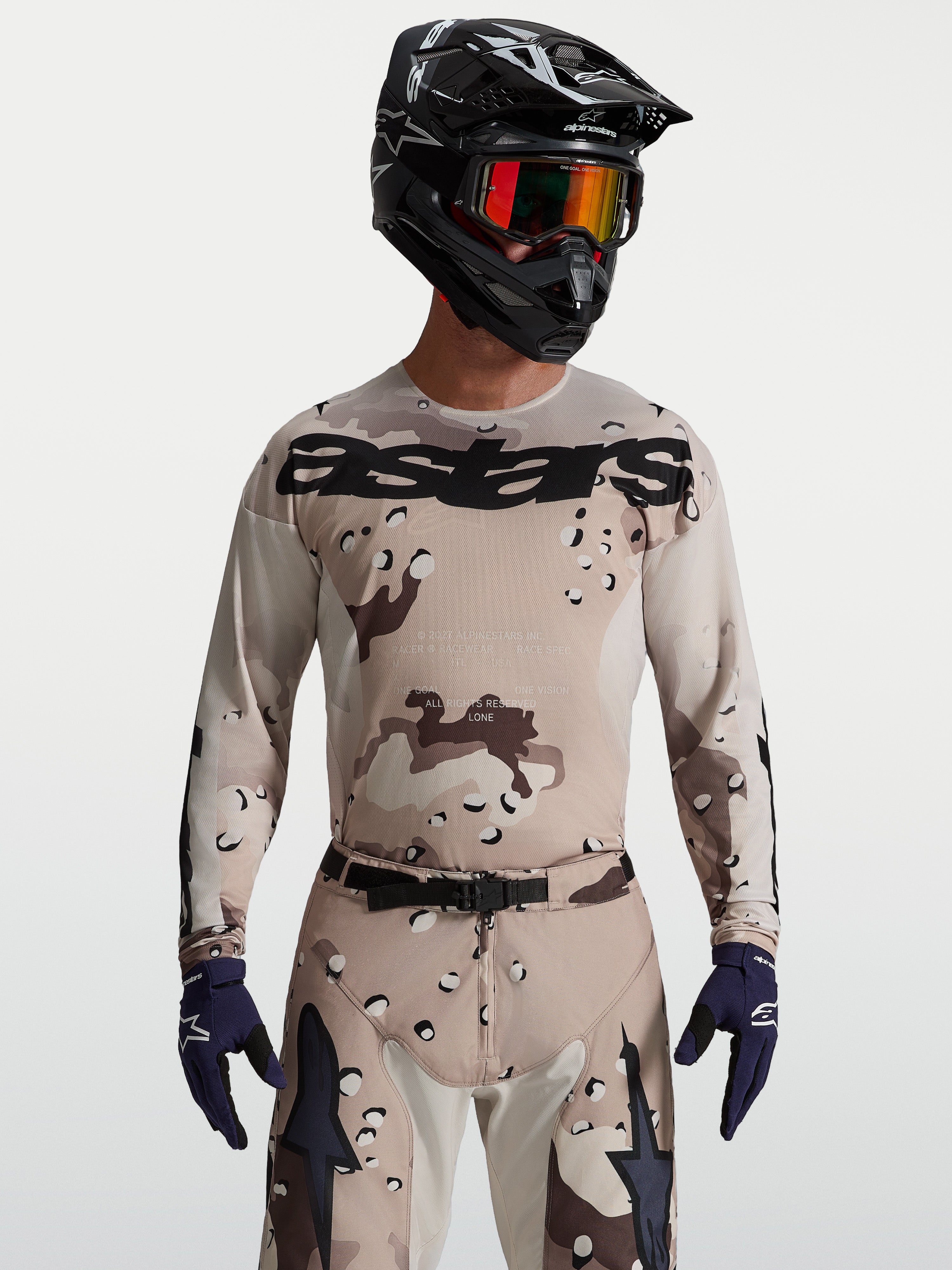 Alpinestars camisola Racer Lone, camisola de motocross para homem, bege e preta com camuflagem deserto, modelo com capacete.