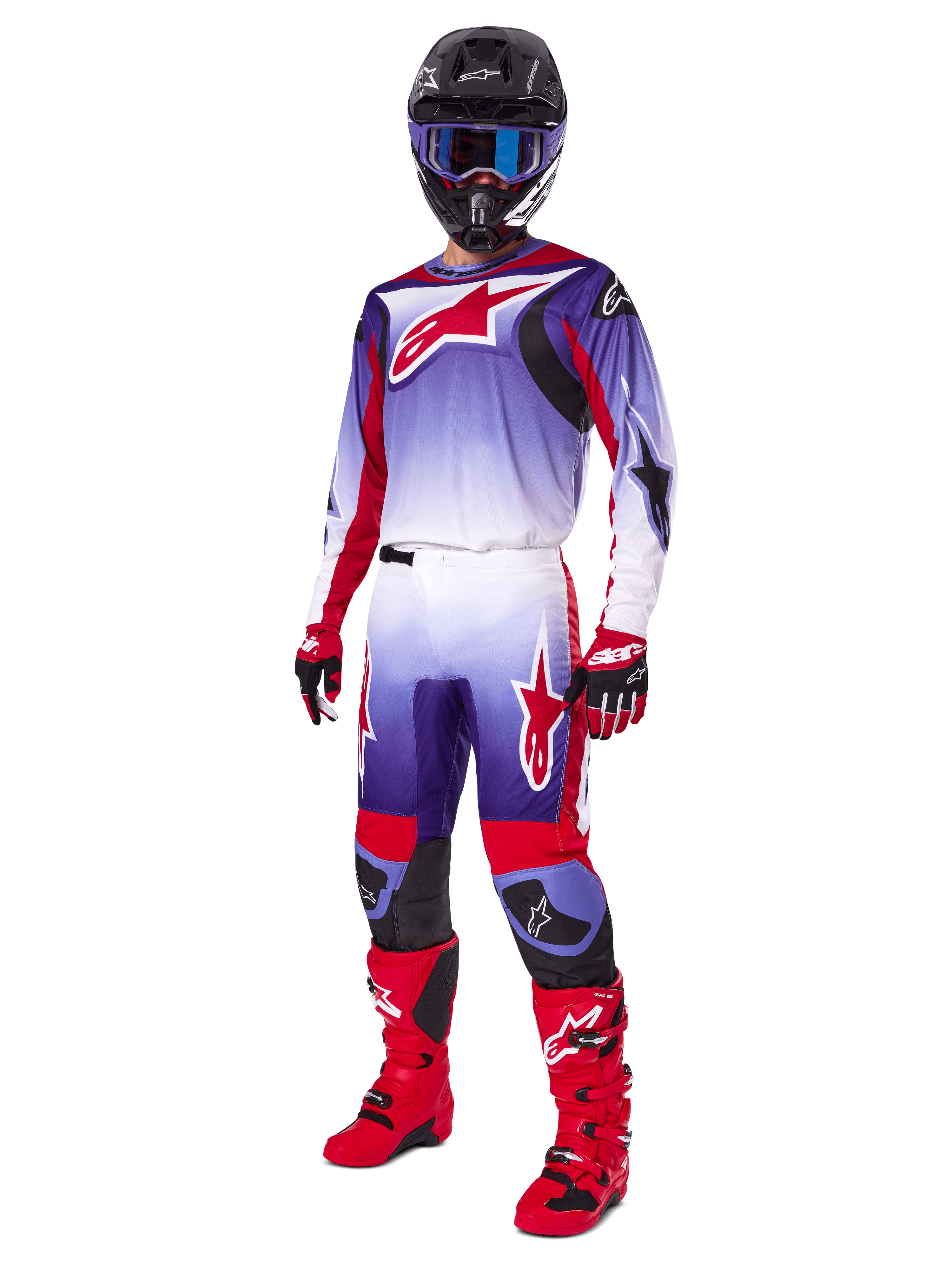 Piloto de motocross a usar o Conjunto de Equipamento Alpinestars 2025 Fluid Wurx, camisola roxa e vermelho vivo com detalhes brancos, calças de motocross a condizer, botas vermelho vivo, capacete preto com óculos de proteção azuis, e luvas vermelhas e pretas, equipamento profissional completo para corridas todo-o-terreno