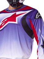 Alpinestars 2025 Fluid Wurx Jersey, camisola de motocross, roxo e vermelho vivo, grande plano de piloto a usar a camisola com grande logótipo de estrela vermelho da Alpinestars no peito, pormenores gráficos curvos em preto e vermelho, corte atlético para competição todo-o-terreno