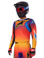 Conjunto de Equipamento Alpinestars 2025 Fluid Wurx, conjunto de motocross, degradê em laranja, roxo e azul, com um grande logótipo A-stars preto, usado com capacete preto e óculos azuis, conjunto coordenado para corridas profissionais de todo-o-terreno