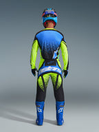 Rear view of a motocross rider wearing the 2026 Techstar Nomur Jersey in Dark Navy, Yellow Fluo, and UCLA Blue, paired with matching yellow and black motocross pants featuring 'Astars' branding, blue racing boots, and a coordinated helmet, complete professional gear for off-road racing.