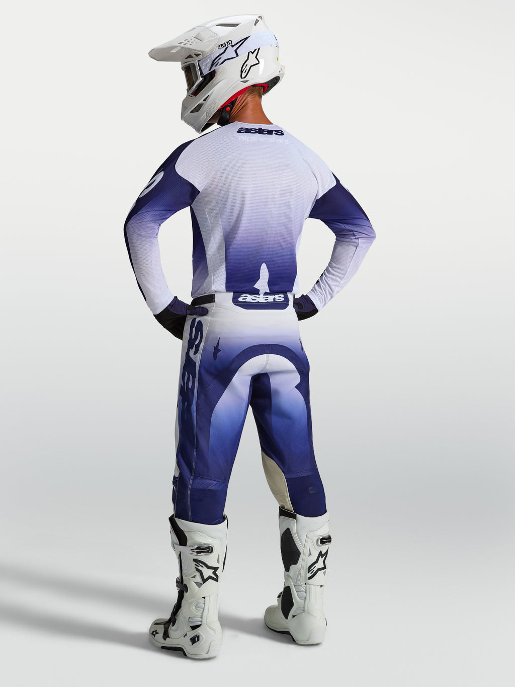 Alpinestars Racer Air Amber camisola e conjunto de equipamento de motocross em azul-marinho e branco, vista traseira em modelo com equipamento de corrida completo.