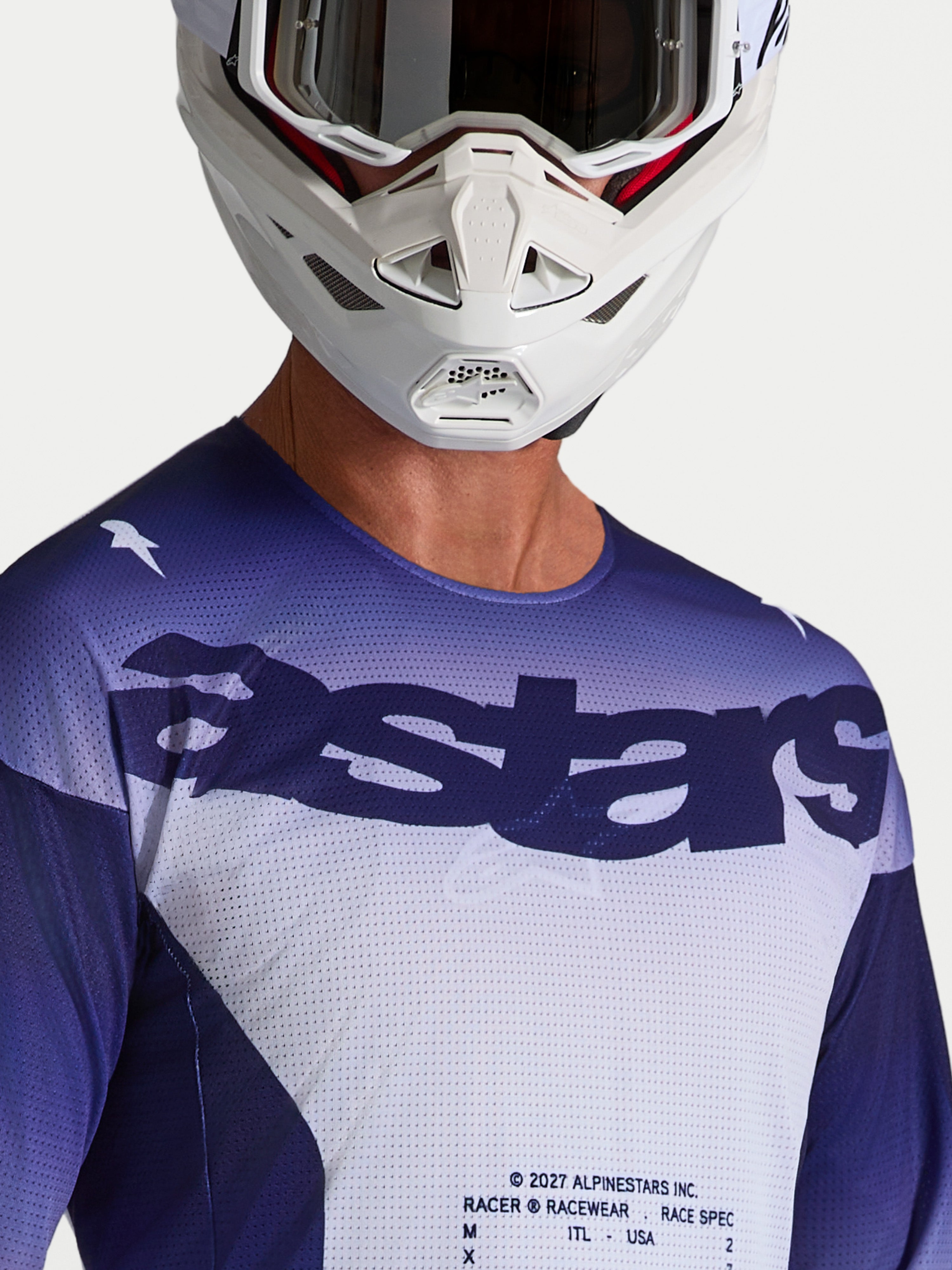 Alpinestars Racer Air Amber, camisola de motocross azul e branca para homem, em malha com logótipo astars, modelo com capacete.
