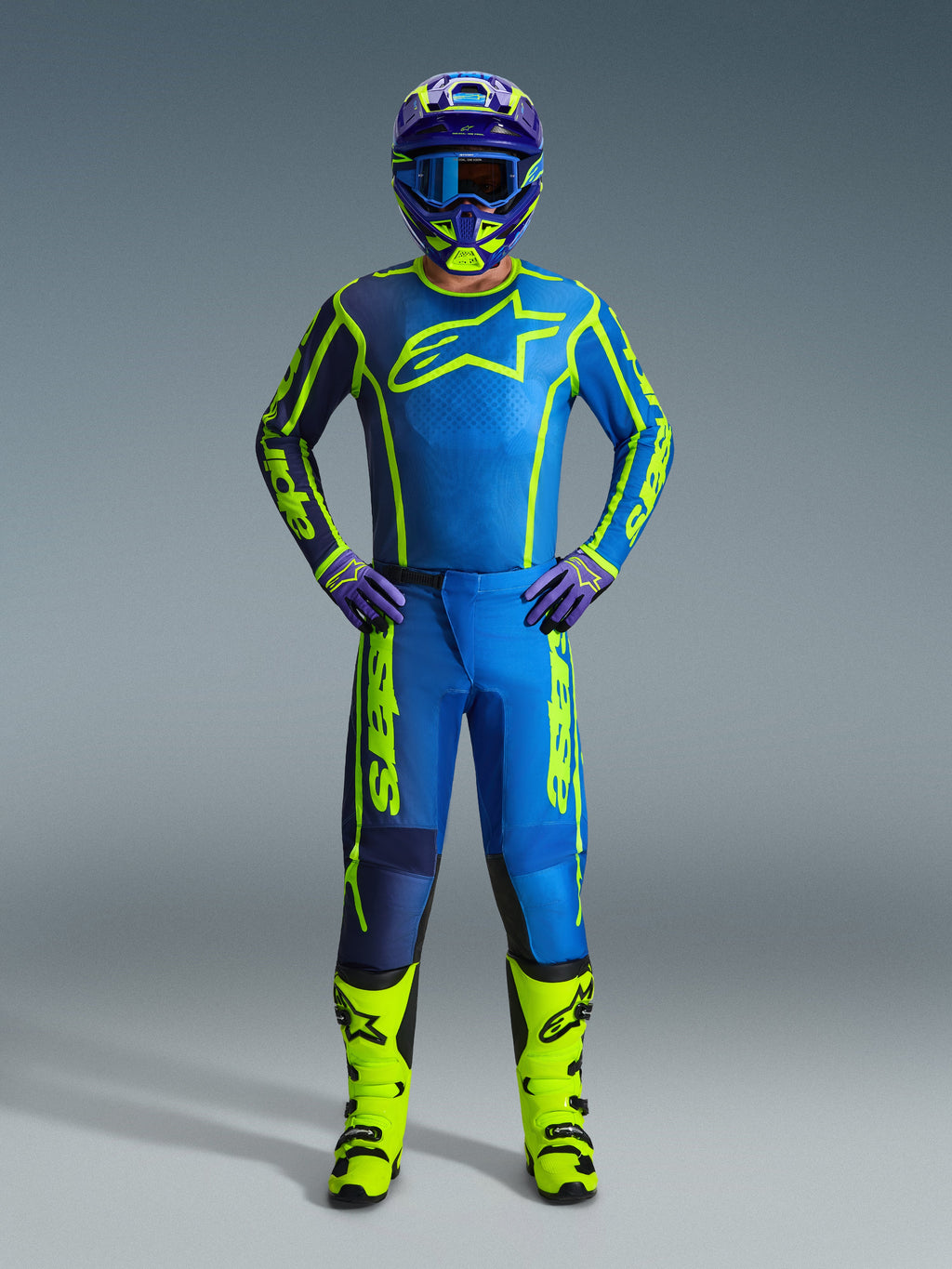 Piloto de motocross com equipamento de corrida completo, Camisola Fluid Apex 2026 em azul e amarelo néon, calças a condizer, botas amarelo néon, e capacete coordenado com óculos azuis, kit de corrida off-road profissional
