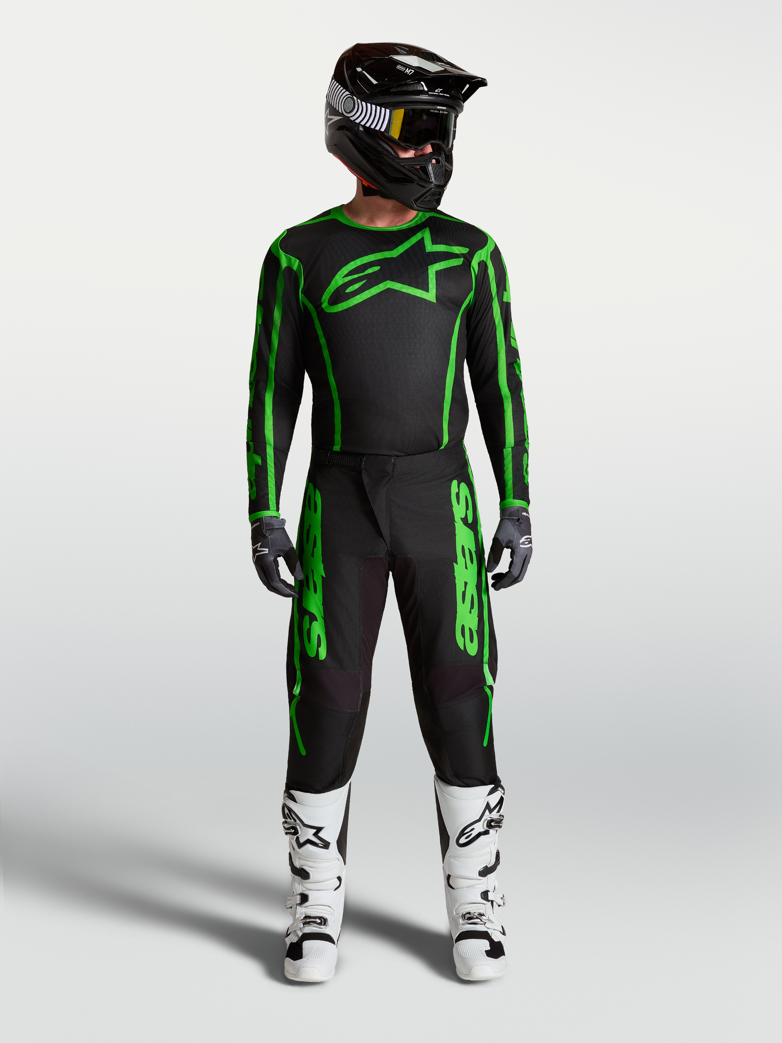 Alpinestars Fluid Apex V2, camisola e conjunto de motocross para homem, preto e verde fluo, com calças e botas brancas.