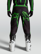 Alpinestars Calças Fluid Apex V2, calças de motocross para homem, pretas e verdes florescentes, com gráficos de estrelas, vista traseira no modelo