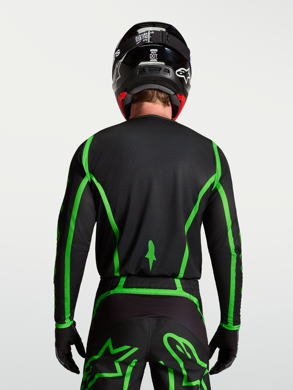 Camisola Alpinestars Fluid Apex V2 para motocross, preta e verde fluorescente, vista traseira com corte longo no modelo.