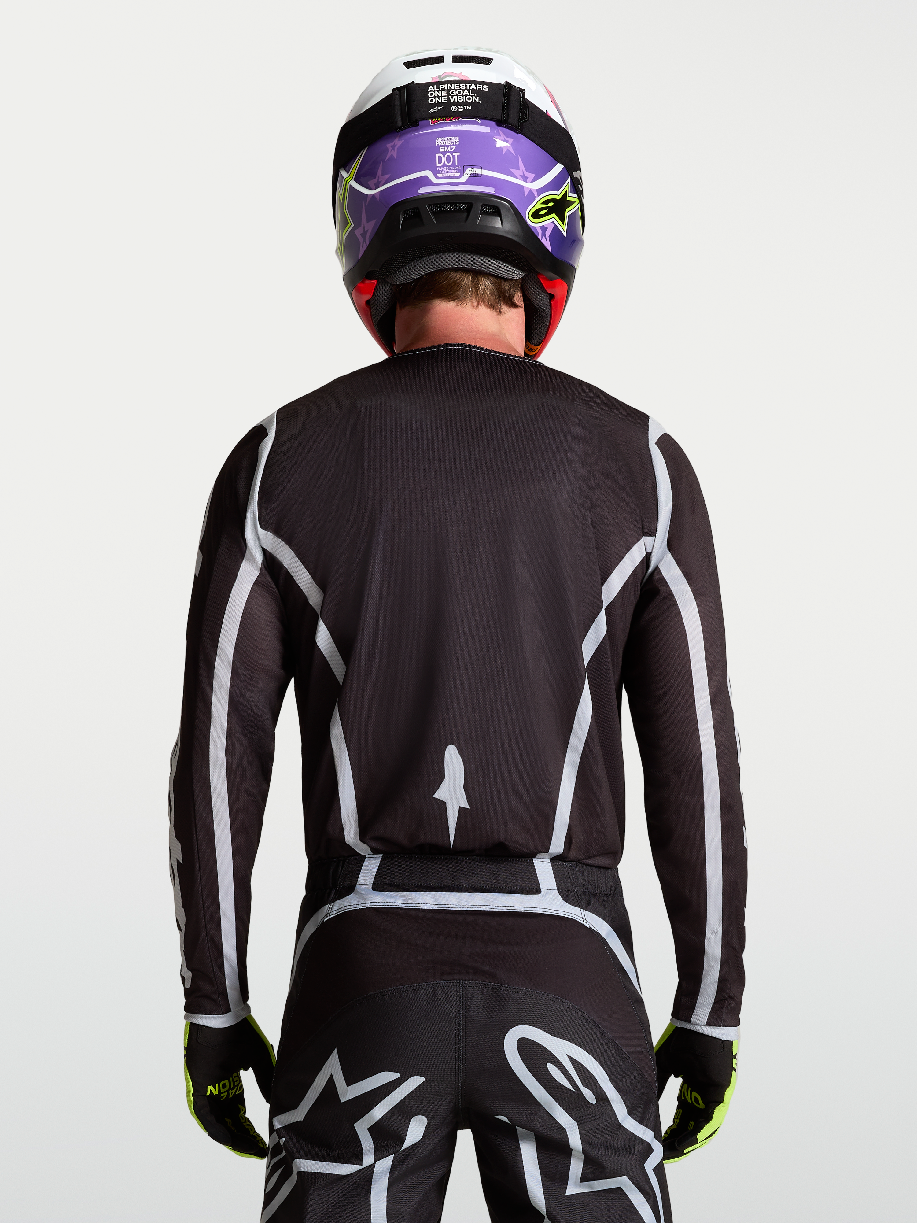 Alpinestars Camisola Fluid Apex V2, camisola de motocross para homem, preta e prateada, vista traseira no modelo com ajuste atlético ergonómico.