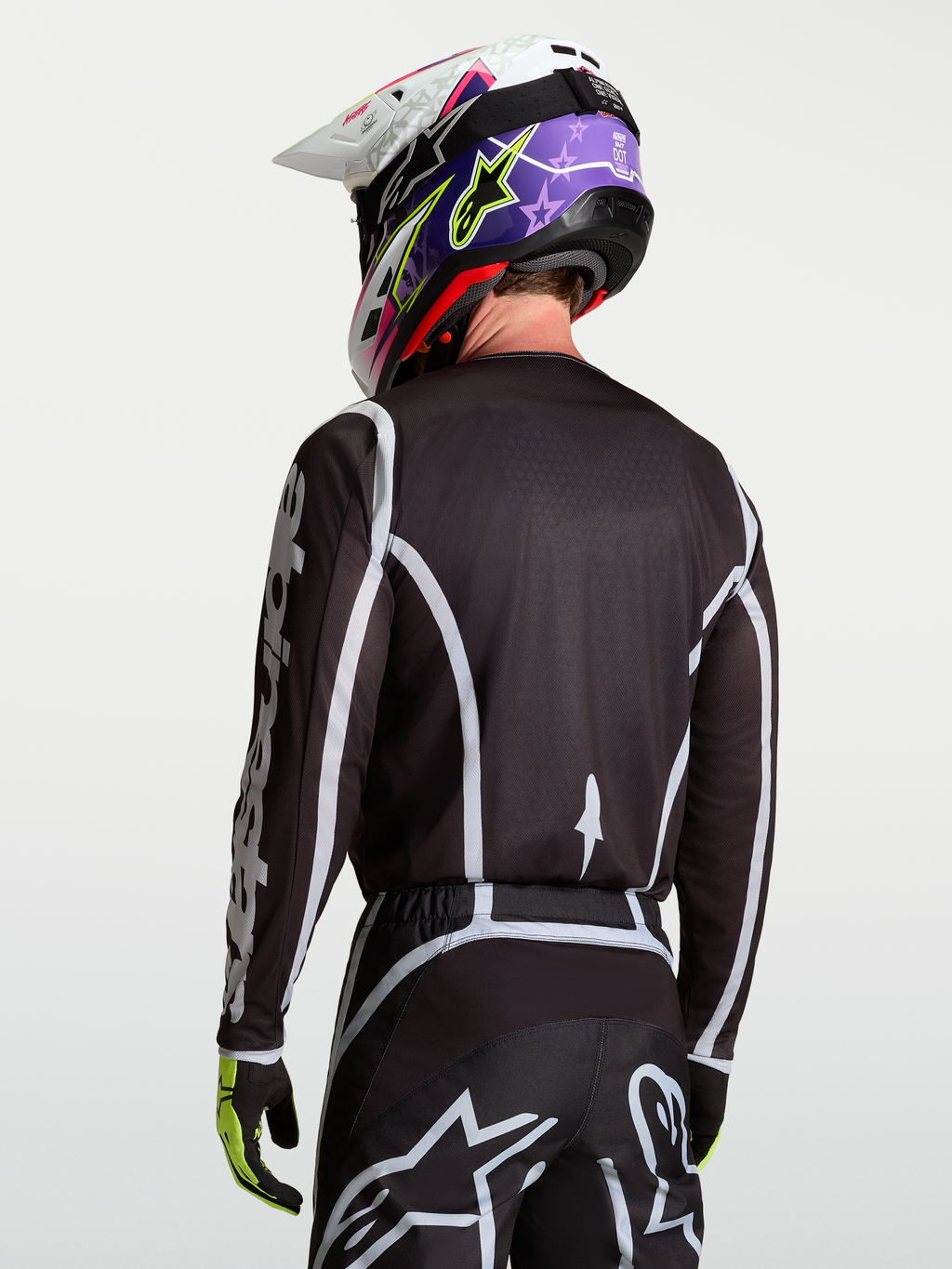 Alpinestars Camisola Fluid Apex V2, camisola de motocross para homem, preta e prateada, vista traseira em modelo, material leve e respirável para todo-o-terreno