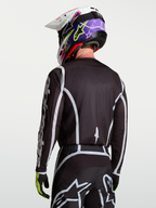Alpinestars Camisola Fluid Apex V2, camisola de motocross para homem, preta e prateada, vista traseira em modelo, material leve e respirável para todo-o-terreno