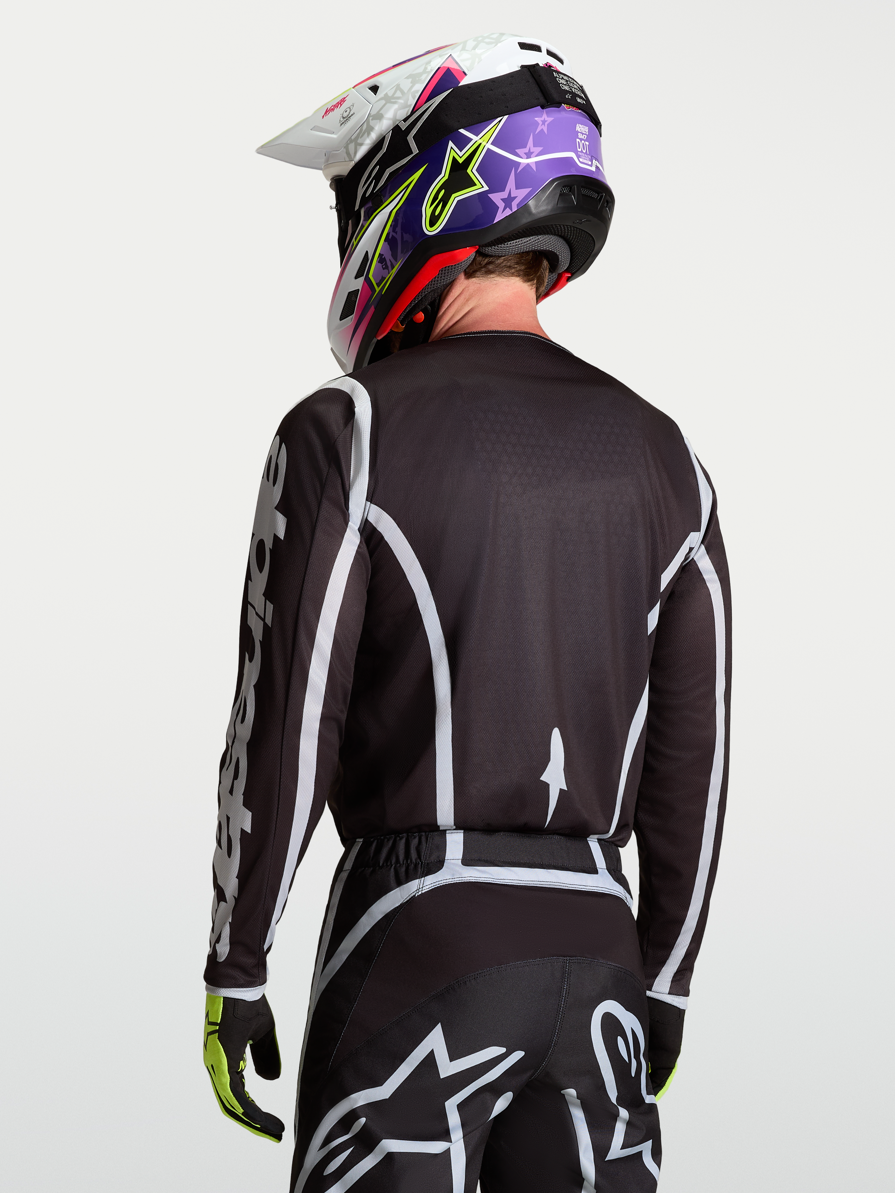 Alpinestars Camisola Fluid Apex V2, camisola de motocross para homem, preta e prateada, vista traseira em modelo, material leve e respirável para todo-o-terreno
