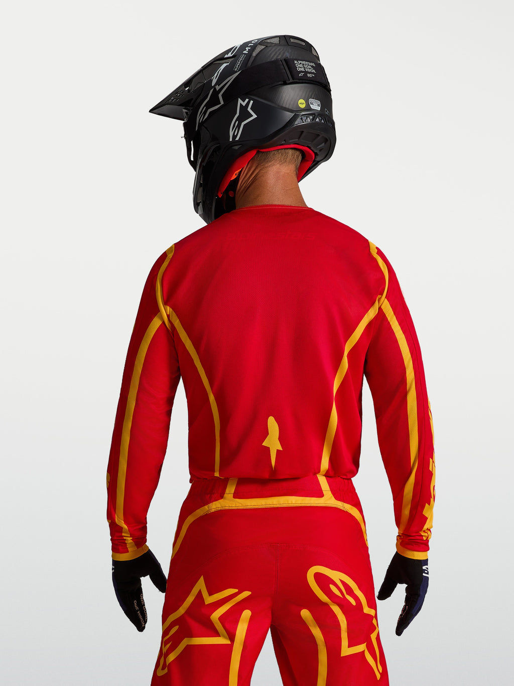 Alpinestars Fluid Apex V2, camisola de motocross para homem, vermelha e dourada, vista traseira com tecido respirável.