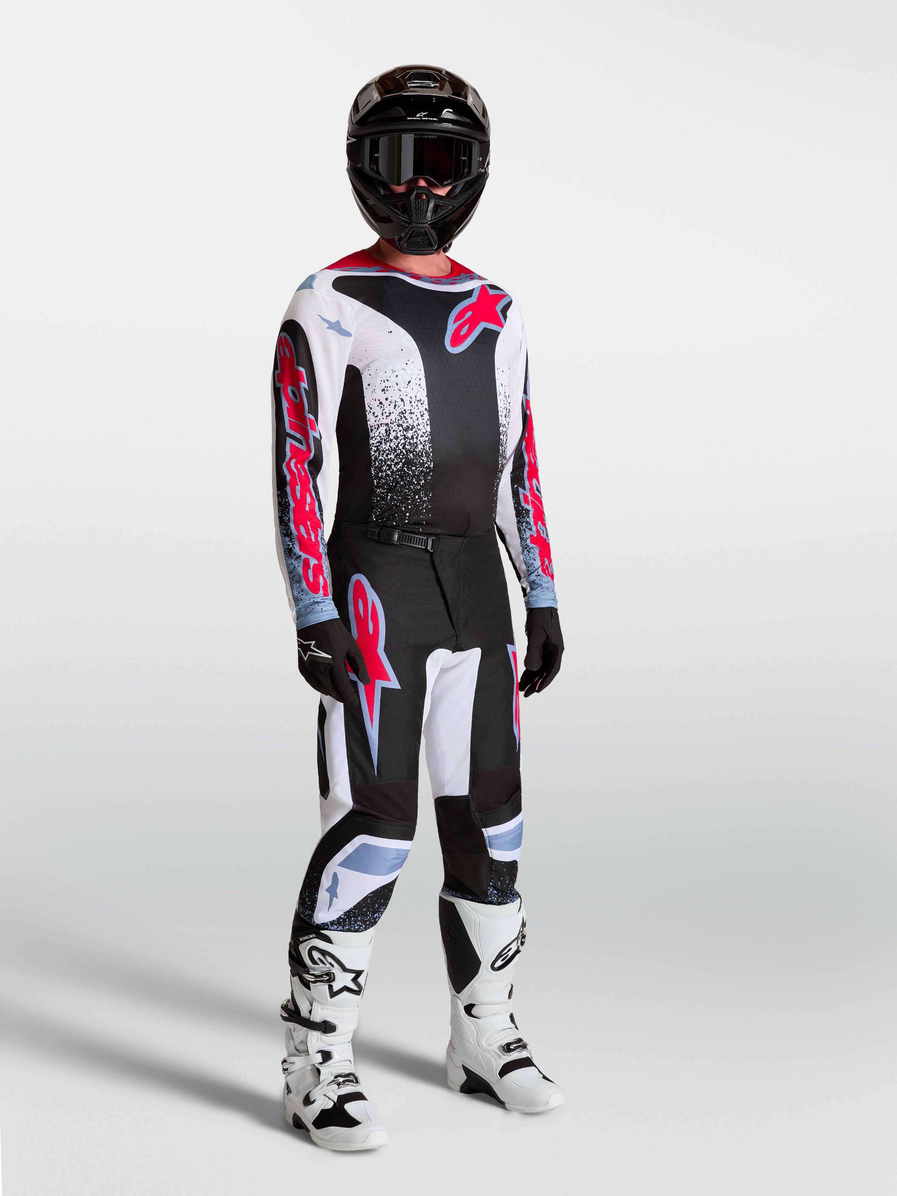 Alpinestars 2027 Fluid Drag Gear Set, conjunto de motocross masculino, preto e branco com gráficos vermelhos e botas brancas.