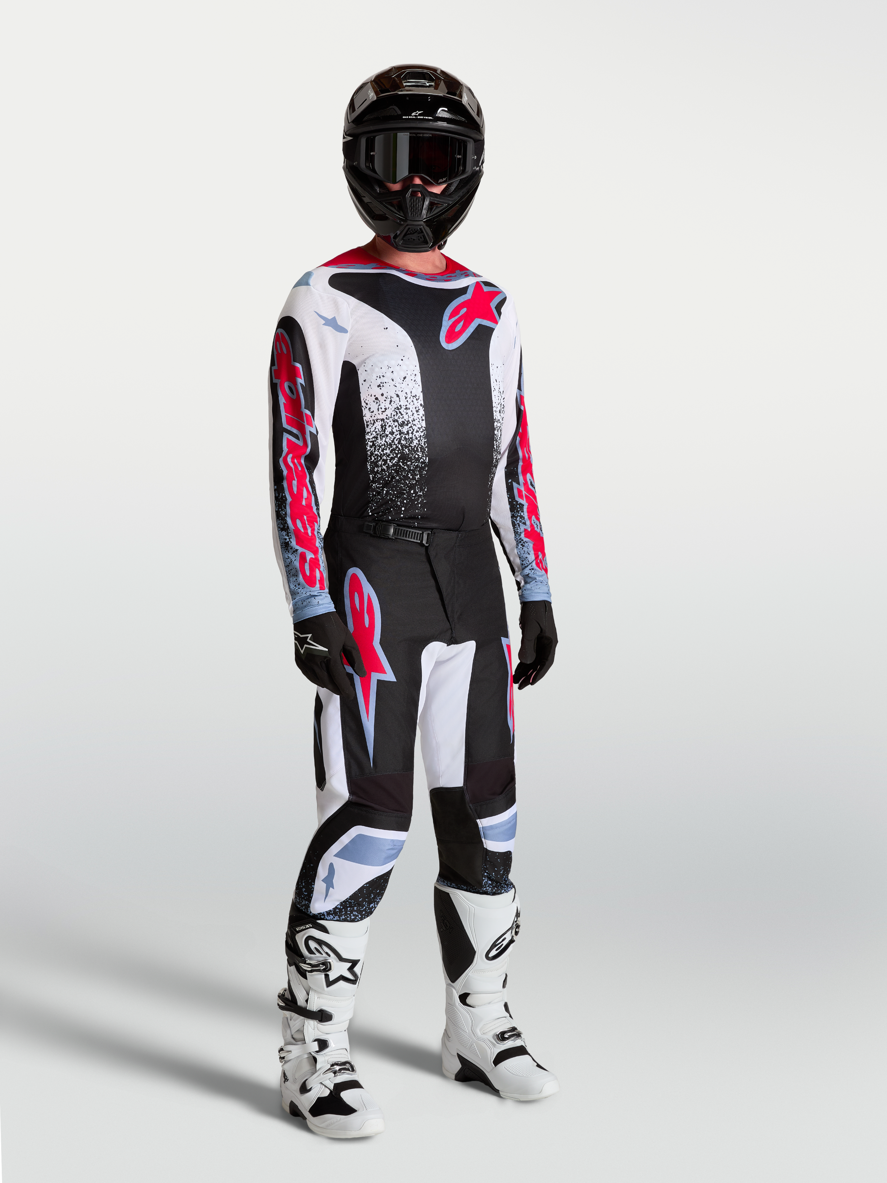 Alpinestars Fluid Drag, camisola de motocross para homem, preta, branca e vermelha fluorescente, modelo com equipamento.