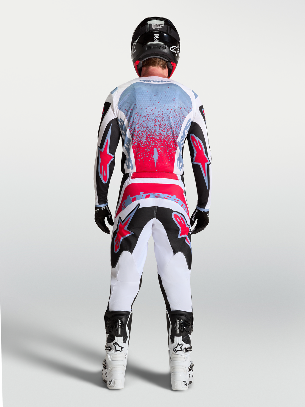 Alpinestars camisola Fluid Drag de motocross para homem, preta e vermelha fluo, vista traseira num piloto, design de performance para todo-o-terreno