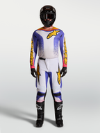Alpinestars camisola Fluid Drag e conjunto Gear Set, equipamento de motocross para homem em azul e dourado, com tecido elástico ergonómico e design de alto desempenho para todo-o-terreno.