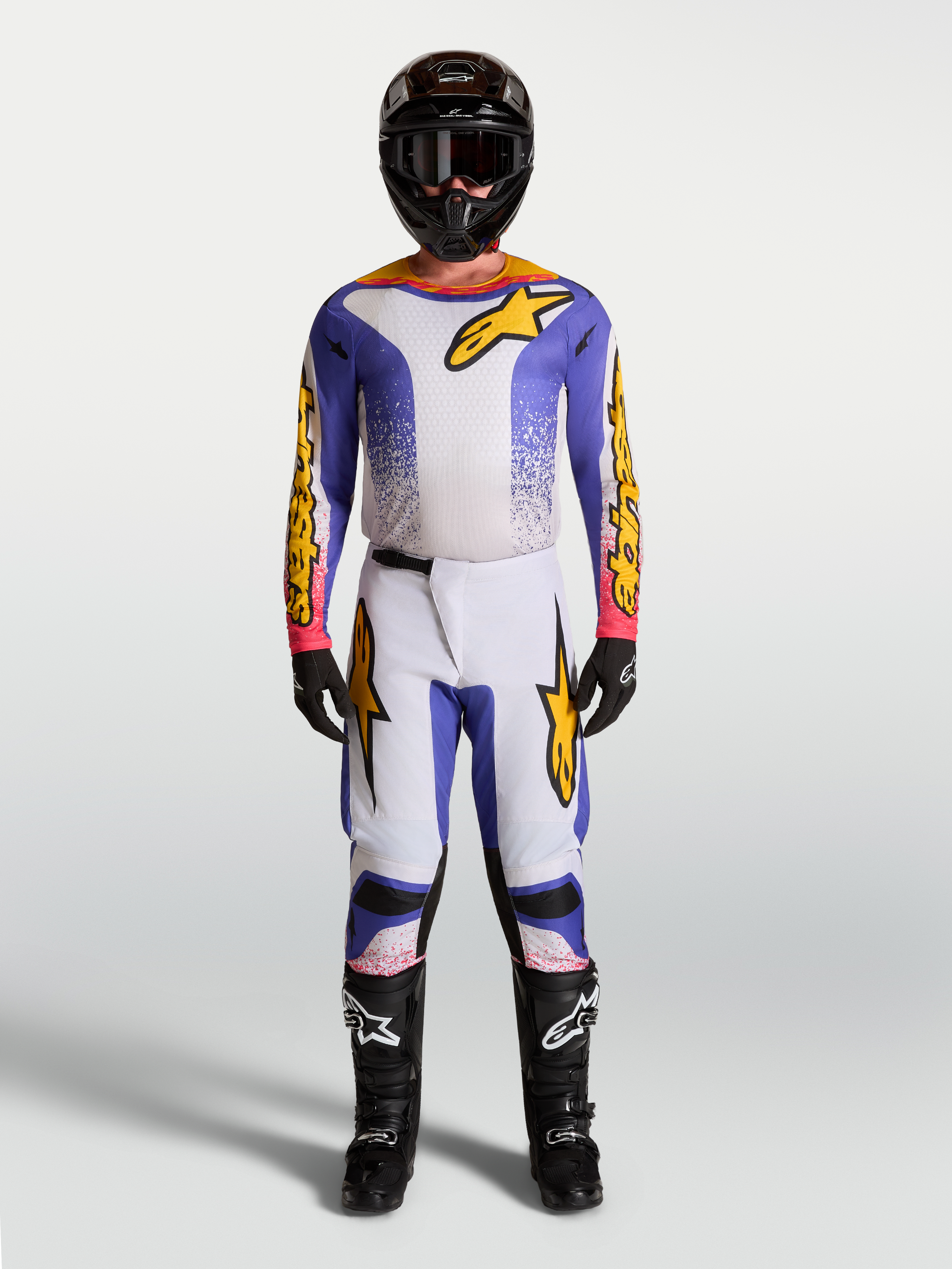 Alpinestars camisola Fluid Drag e conjunto Gear Set, equipamento de motocross para homem em azul e dourado, com tecido elástico ergonómico e design de alto desempenho para todo-o-terreno.