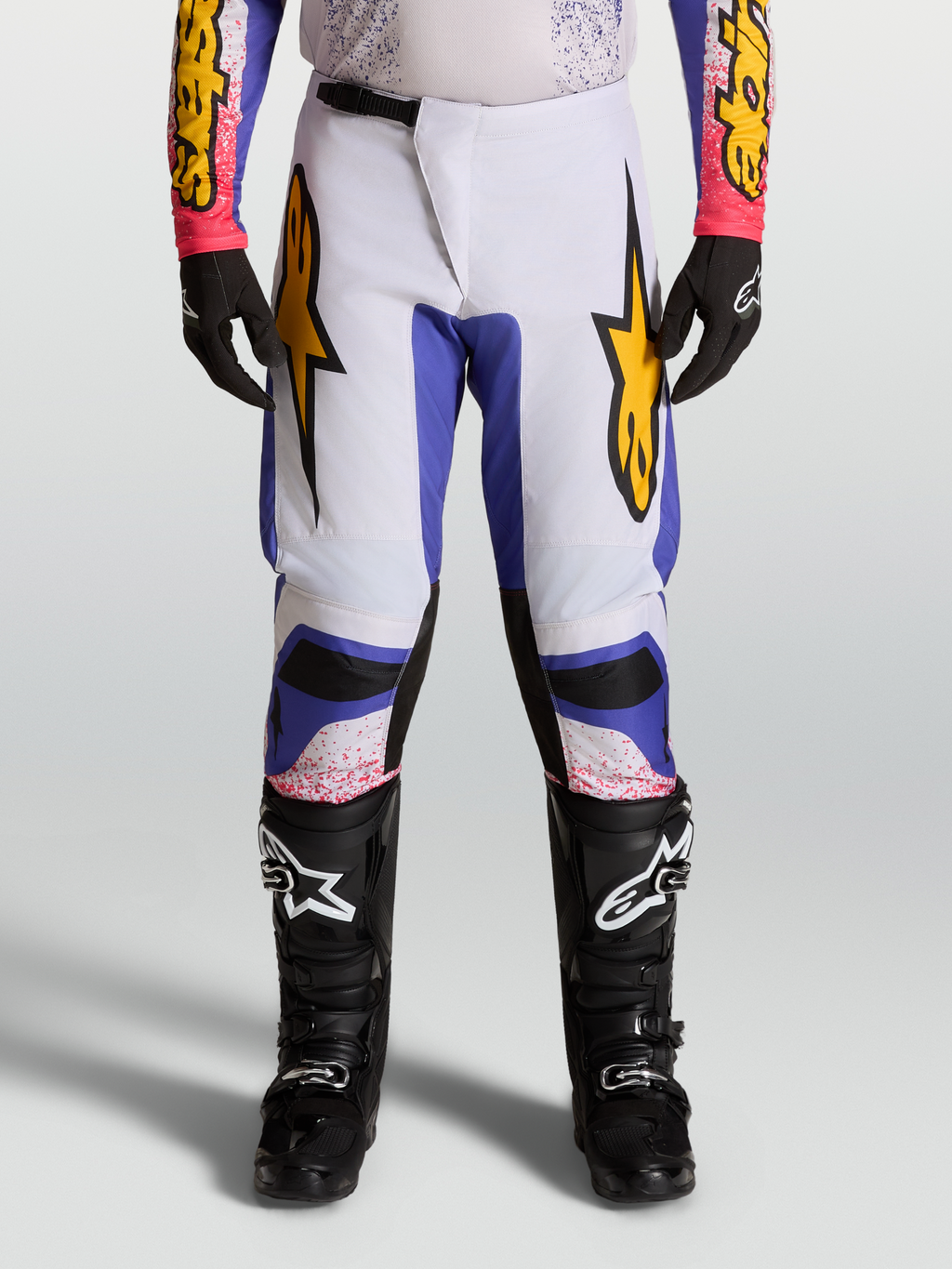 Alpinestars Fluid Drag 2027, calças de motocross para homem em lilás claro e azul com pormenores dourados.