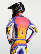 Alpinestars Camisola Fluid Drag, camisola de motocross azul e dourada, com corte traseiro ergonómico e tecido respirável.