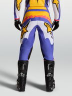 Alpinestars Calças Fluid Drag, calças de motocross em azul e dourado, vista traseira, assento reforçado e botas pretas.
