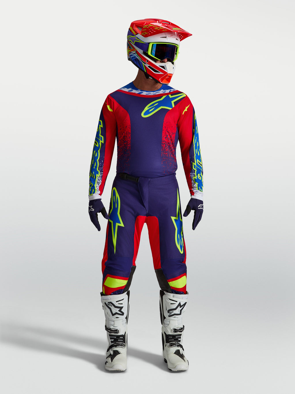 Alpinestars camisola Fluid Drag e Gear Set, equipamento de motocross azul-marinho e vermelho com botas brancas e capacete.