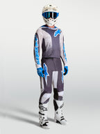 Alpinestars camisola Fluid Drag, equipamento de motocross para homem, cinzento e azul, com capacete e botas de moto.
