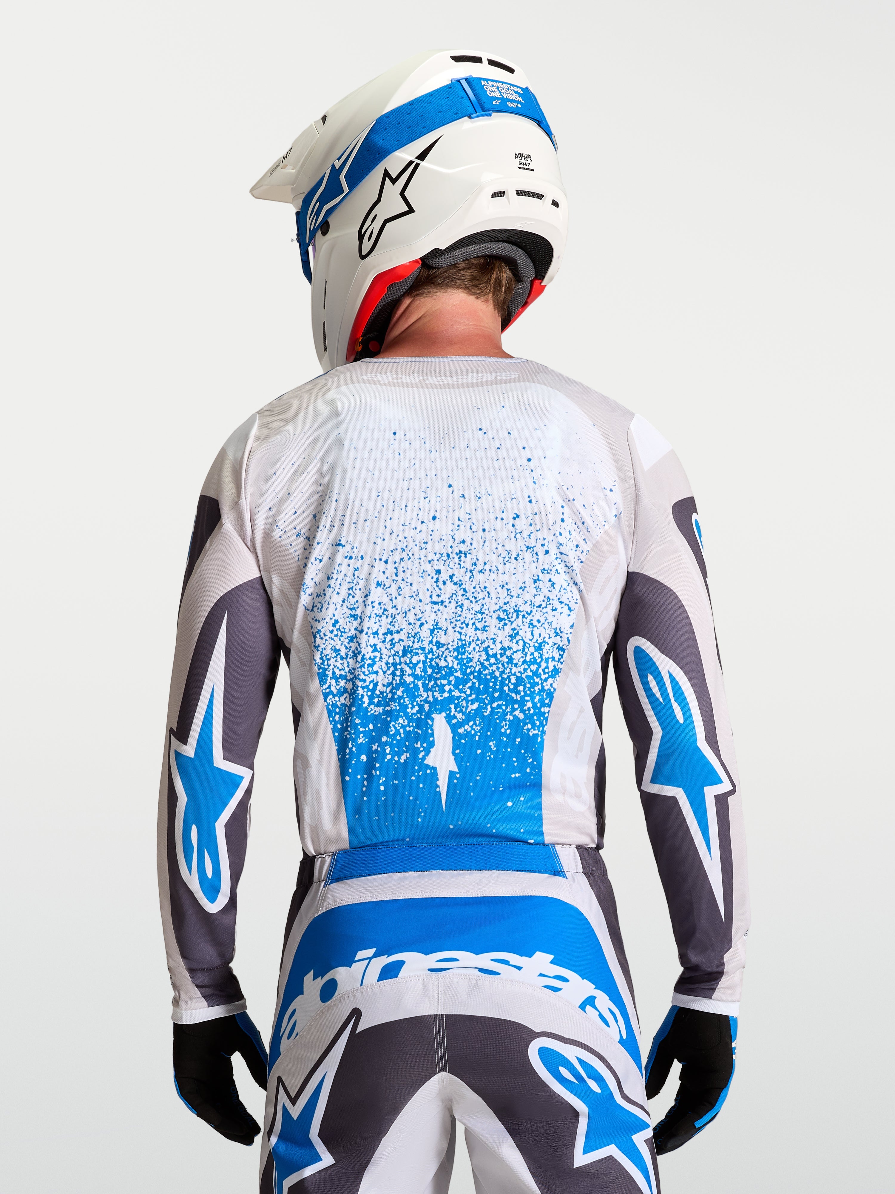 Alpinestars Camisola Fluid Drag, equipamento de motocross respirável para homem em cinzento e azul, vista traseira.