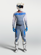 Alpinestars Racer Amber, calças e camisola de motocross para homem, cinzento e azul, com botas e capacete brancos.
