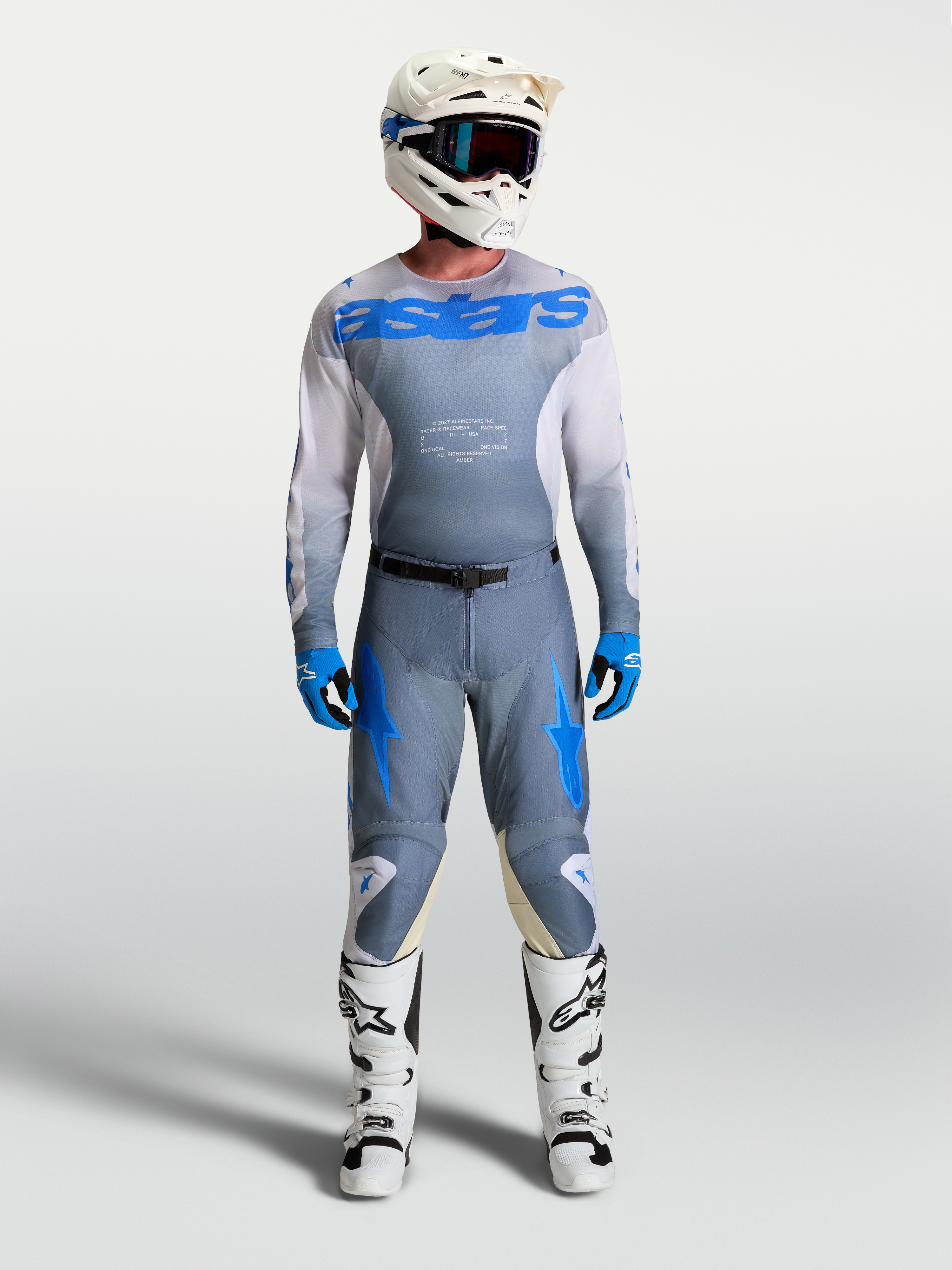 Alpinestars Camisola Racer Amber e Racer Amber Gear Set, conjunto de equipamento de motocross para homem, cinzento e azul, com capacete e botas brancas.