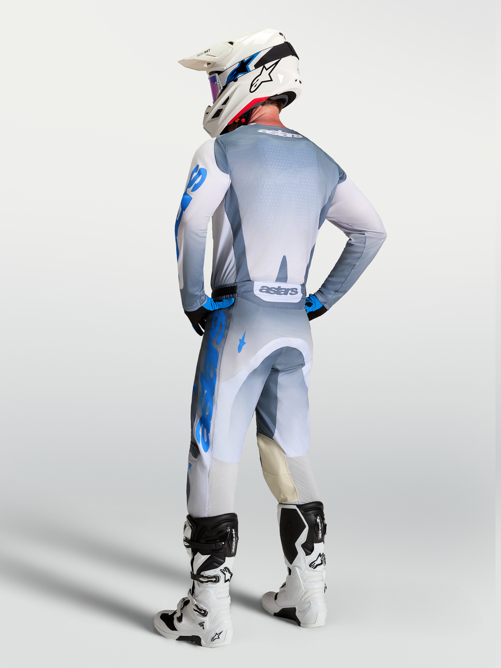 Alpinestars calças e gear set Racer Amber 2027, equipamento de motocross cinzento e azul, vista traseira num piloto.