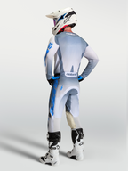 Alpinestars calças e gear set Racer Amber 2027, equipamento de motocross cinzento e azul, vista traseira num piloto.
