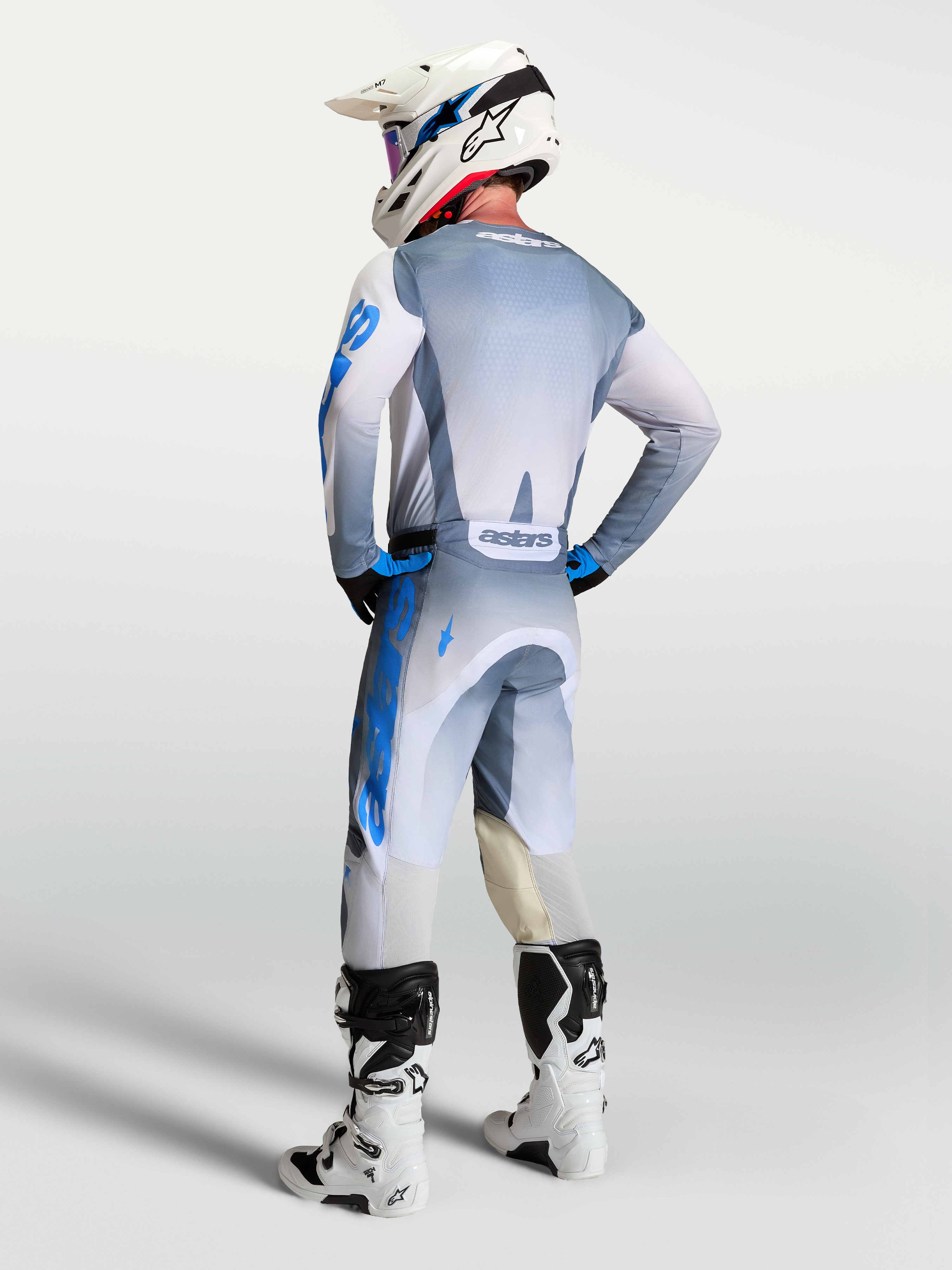 Alpinestars Racer Amber, camisola de motocross para homem, cinzenta e azul, vista traseira com ajuste de corrida ergonómico.