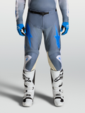 Alpinestars Calças Racer Amber 2027, calças de motocross para homem cinzentas e azuis com botas brancas.
