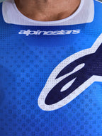Camisola Alpinestars 2026 Racer Air Portl, camisola de motocross, azul Ucla e branco, grande plano do peito mostrando o tecido de malha perfurada respirável, acabamento da gola em branco e logótipos Alpinestars estilizados