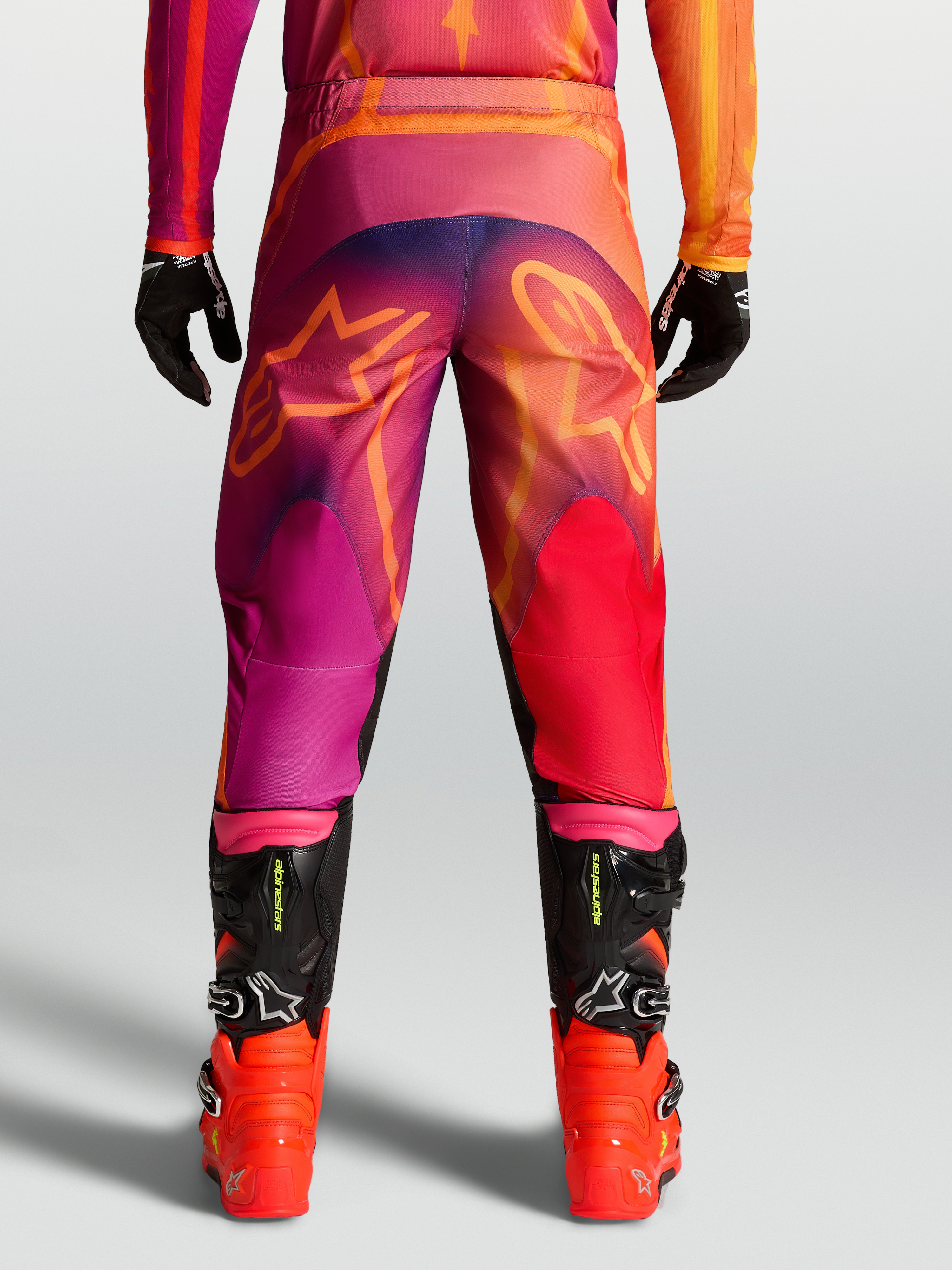 Alpinestars Cal''as Fluid Kepler, cal''as de motocross para homem, roxa e laranja, vista traseira com log''tipo Astars.