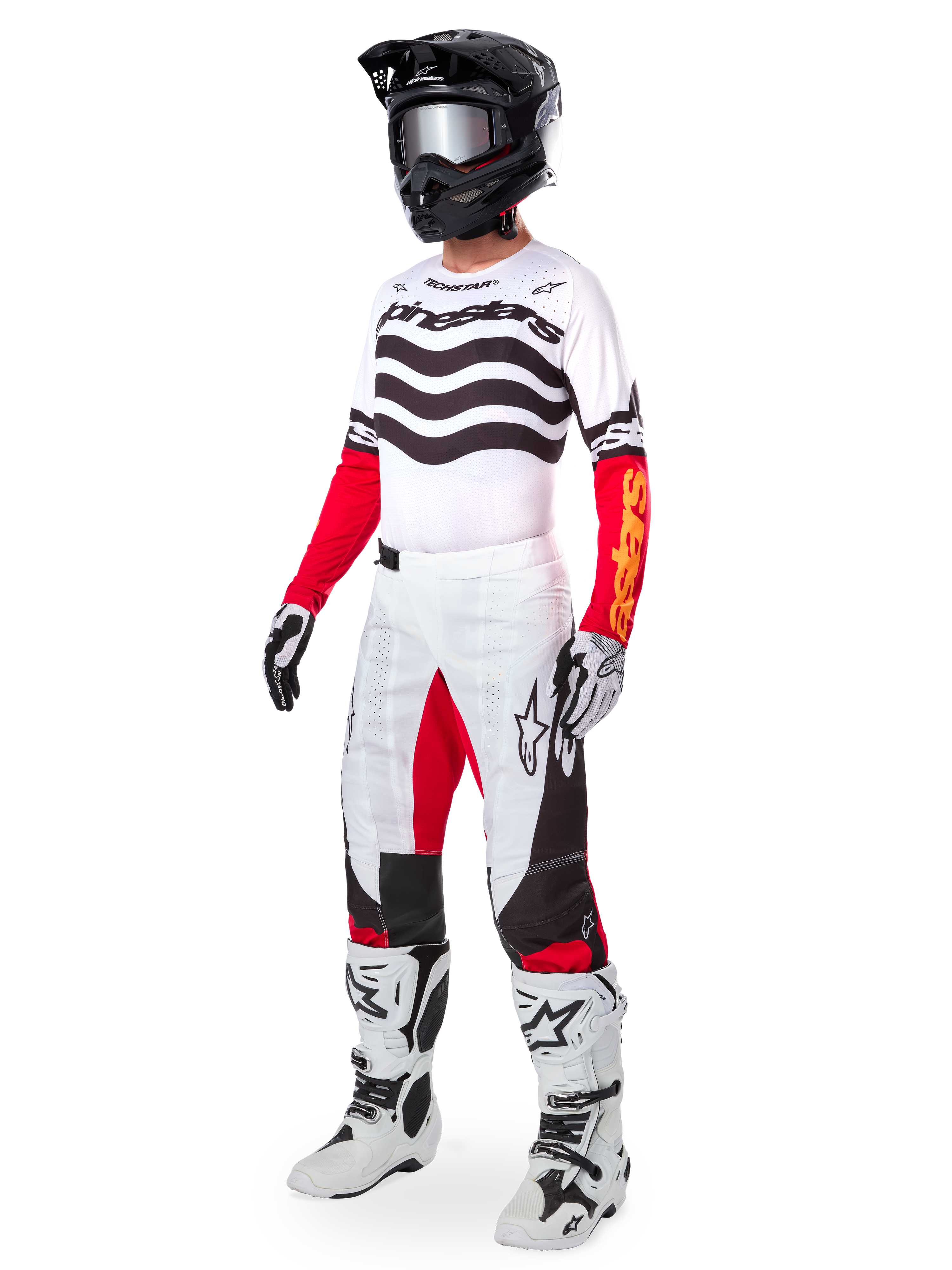 Motocross rider wearing complete racing gear, Limited Edition Techstar Deep Jersey with white and black wavy stripes and red sleeves, matching white and red pants, black helmet, white and black boots, coordinated outfit for off-road racing